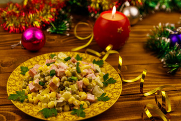 Tasty festive salad, Christmas decor and candle on wooden table