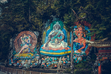 Naklejka premium Tibetan murals in the stone wall carvings of Dongga Temple, Hailuogou, Sichuan, China, Thangka, rock carving