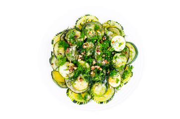 Fried zucchini with green greens, garlic and walnuts.