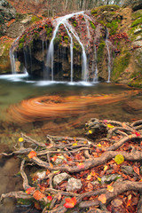 Fototapeta na wymiar Beautiful autumn landscape with a waterfall in the autumn forest.