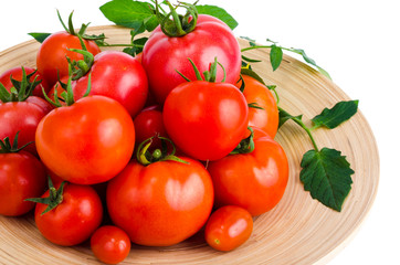 Wooden dish with different ripe tomatoes on white background.