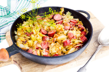 Fried cabbage with smoked sausages in pan
