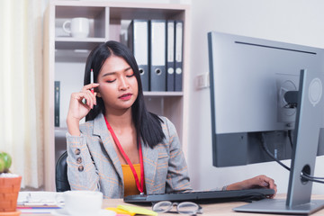 Concentrated young business woman working in office, charming Asian woman accountant looking documents and working on computer