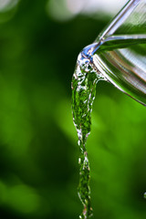 Pouring water out of the glass  and natural background