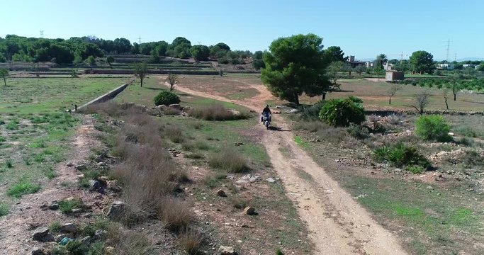 Vuelo de dron encima de motocicleta de trail de gran cilindrada circuito de tierra en oasis