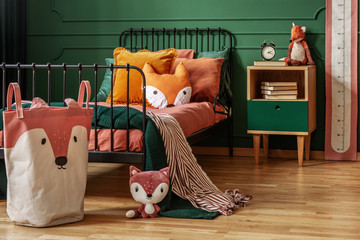 Fox theme in cute bedroom interior with green wall and orange bedding