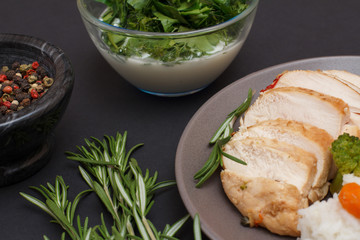 Baked chicken breasts or fillet on plate with rice and vegetables on plate.