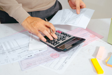 Hand man doing finances and calculate on desk about cost at home office.