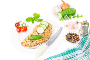 Bread slice with chicken rillettes close up on white plate.