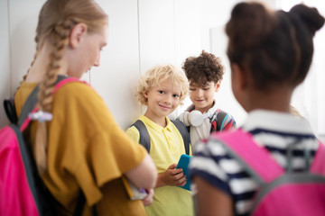 Classmates standing near lockers and enjoying school break