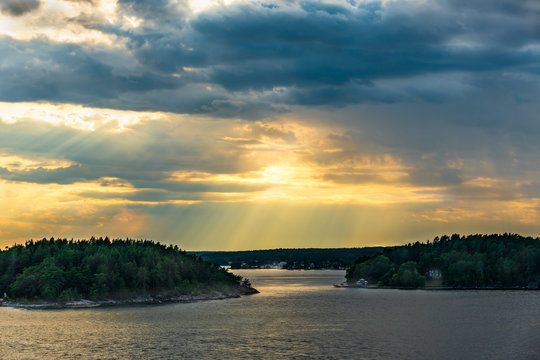 Beautiful summer Scandinavian midnight sun. Dramatic cloud sunset over islands and sea in the Swedish archipelago.