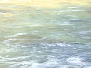 a slow shutter speed renders a stream's water silky and smooth  in a river in Kings Canyon National Park, California