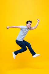 Fototapeta na wymiar Fun energetic young handsome Asian man jumping in mid-air