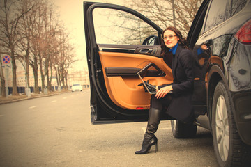 woman with a laptop sitting on the threshold of the vehicle