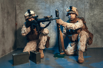 US special operations forces fighters armed with assault rifle, in opscore helmet. Studio shot