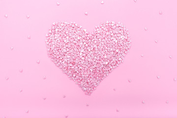 Pink background. Pink hearts on a pink background. Hearts sprinkles.  Flat lay style. Top view. Sweet background. Confetti.