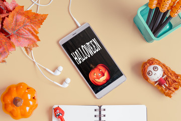 Flat lay Happy Halloween Mobile phone mockup background concept. Top view of smartphone on office desk table with Halloween accessories. Flat lay design.