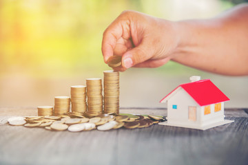 Hold put on the stack coin with growing in the public park, Savings money for buy house and loan to business investment for real estate concept.