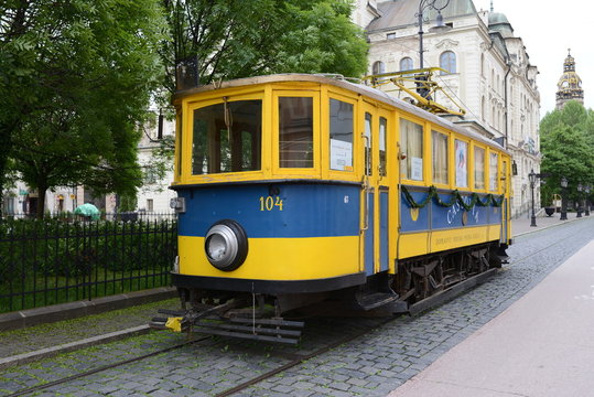 blue and yellow tram on the street of the ancient city close-up © Ольга Козырькова