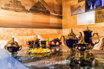 Kirov, Russia - July 18, 2018: Very beautiful and expensive porcelain tea set including cups, plates, kettle standing on a shiny table