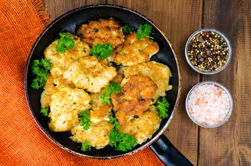 Fried meat pancakes in pan, vegetables, wooden background