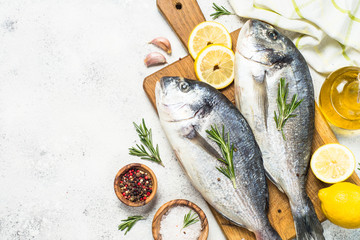 Raw dorado fish on cutting board on the table.