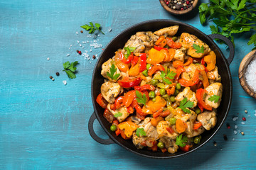 Chicken Stir fry with vegetables on blue table.