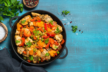 Chicken Stir fry with vegetables on blue table.