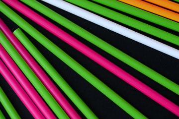 Plastic straws different colors on a dark background close up