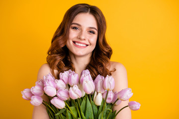 Close up photo of amazing lady holding big bunch of pink tulips in hands isolated yellow background
