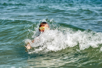 A boy in a stormy raging sea . Safety of children on sea holidays