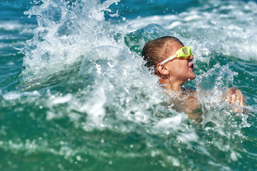 A boy in a stormy raging sea . Safety of children on sea holidays