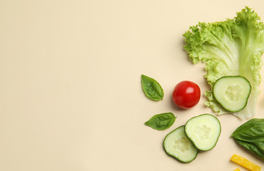 Flat lay composition with fresh salad ingredients on beige background, space for text