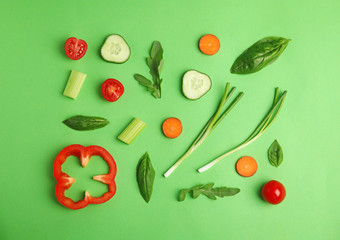 Flat lay composition with fresh ingredients for salad on green background