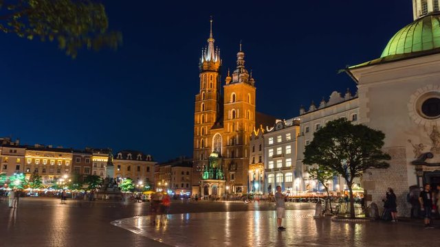 Timelapse, fast motion, view of the central square of Krakow, Bazylika Mariacka, Poland. Historic city center, travel and tourism concept. summer evening, the end of the day, sunset. 