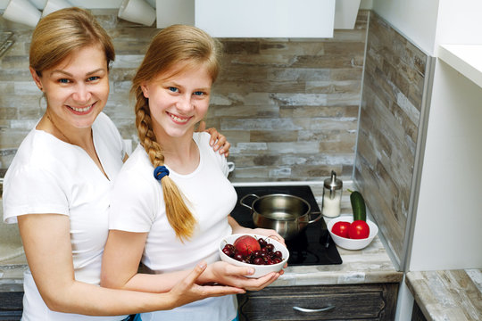 A cute child and mom cook healthy food together.
