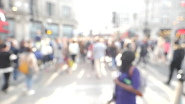 Silhouettes of pedestrians people walking in slow motion on Oxford Circus interchange between the Bakerloo, Central and Victoria lines sunlight flare cinematic HD footage