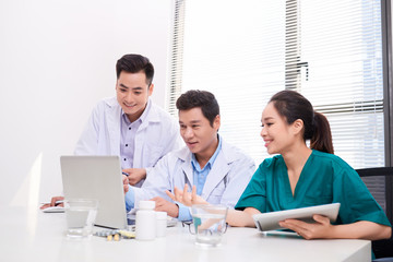 hospital, profession, people and medicine concept - group of happy doctors with tablet pc computers meeting at medical office