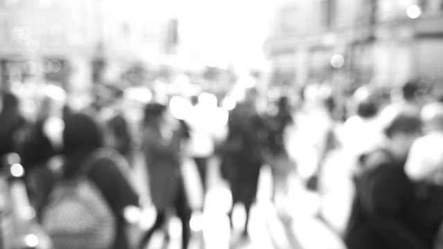 Blur defocused silhouettes of pedestrians people walking in slow motion on Oxford Circus interchange between the Bakerloo, Central and Victoria lines - black and white cinematic footage