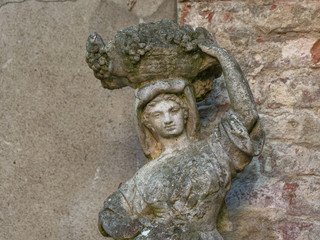 old sculpture of a girl with a pitcher on his shoulder
