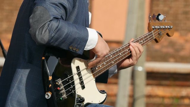 guitarist playing  bass guitar close to