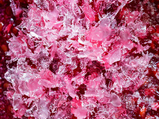 Frozen crystals of water in pink colors, abstract background, macro, top view