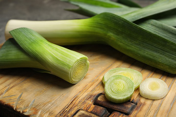 Fresh raw leek on cutting board, closeup. Ripe onion