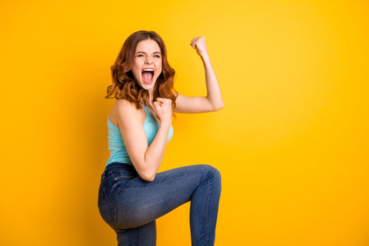 Photo of beautiful trendy pretty cute girlfriend shouting yeah rejoicing her victorious glory extremely wearing turquoise singlet while isolated over yellow bright color background