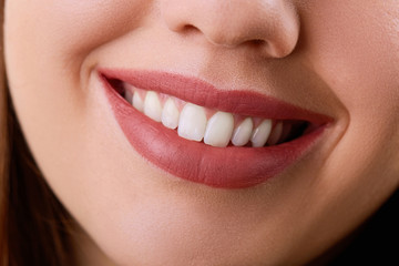 Closeup Beautiful young woman smile. Dental health. Teeth whitening. 