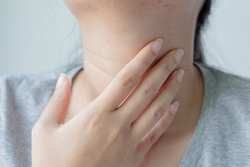 Close up female checking thyroid gland by herself or Sore throat or pain on neck.