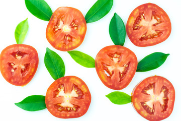Pattern of fresh juicy sliced tomato with green leaves on white background.