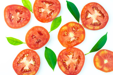 Pattern of fresh juicy sliced tomato with green leaves on white background.