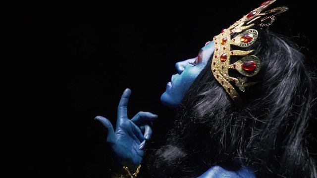 Profile shot of Kali an indian goddess wearing gold jewelry