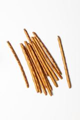 bread sticks scattered on white background, crispy snack with poppy seeds